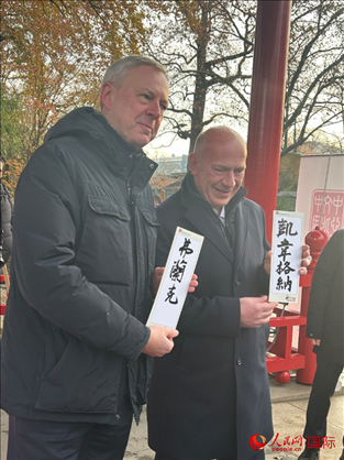 柏林市長(zhǎng)韋格納（右）、動(dòng)物園監(jiān)事會(huì)主席布魯克曼（左）手持中國(guó)文化中心工作人員現(xiàn)場(chǎng)手書(shū)的中文名字。人民網(wǎng)記者 徐馨攝