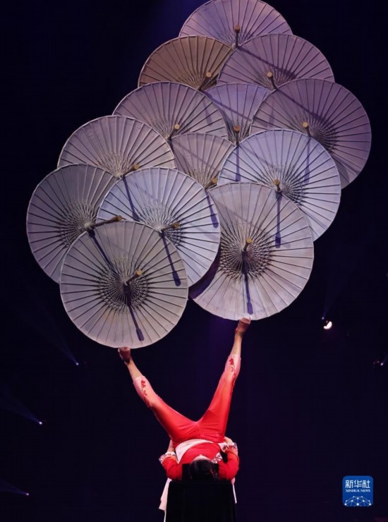 12月8日，演員在法國(guó)巴黎舉行的中國(guó)雜技“奇妙之夜”演出上表演《蹬傘》。新華社記者 高靜 攝