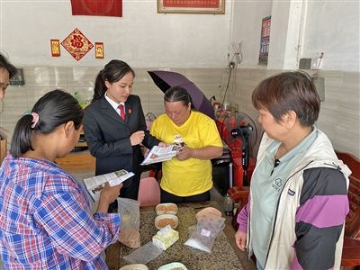  圖⑤：龍圩區(qū)法院法官到群眾家中開展法治宣傳。資料圖片