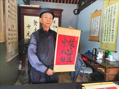 越南首都河內(nèi)文廟內(nèi)，阮明珠展示“中越心相近”書法作品。