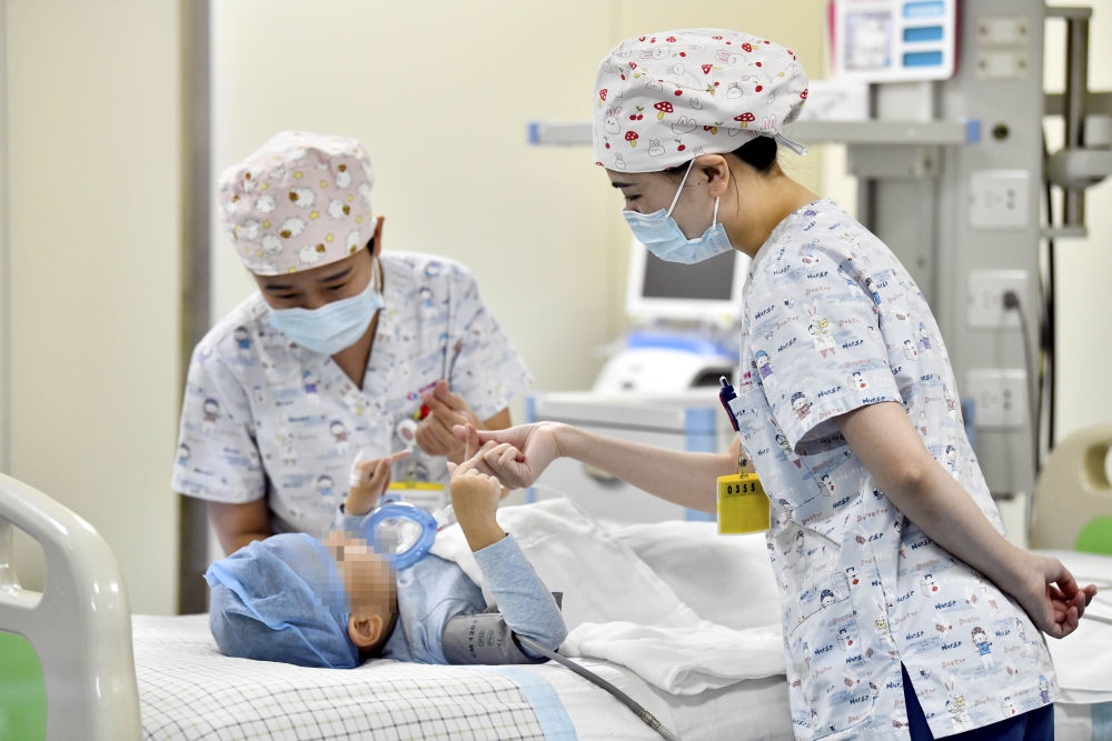 在山東省棗莊市婦幼保健院兒童ICU病房，醫(yī)護(hù)人員為完成靶向治療藥物諾西那生鈉的4歲脊髓性肌萎縮癥患兒加油鼓勁（2022年1月1日攝）。諾西那生鈉注射液是我國首個(gè)獲批治療脊髓性肌萎縮癥的進(jìn)口藥物，2019年進(jìn)入中國市場時(shí)，每針價(jià)格近70萬元。在2021年國家醫(yī)保目錄藥品談判中，以3.3萬元每針的價(jià)格進(jìn)入新版醫(yī)保藥品目錄。新華社記者 郭緒雷 攝