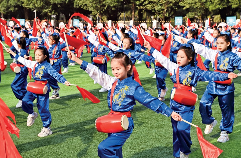 為助推民族地區(qū)基礎教育事業(yè)發(fā)展，廣西重新核定各地中小學教職工編制，依托全區(qū)編制“周轉(zhuǎn)池”核增事業(yè)編制給各地中小學，在全面達到國家標準的基礎上，進一步統(tǒng)籌優(yōu)化和動態(tài)調(diào)整各區(qū)域、學校、學段間編制資源。圖為2023年11月29日，南寧市濱湖路小學舉行主題為“逐夢新時代 健體向未來”的體育文化節(jié)，孩子們正在跳腰鼓舞。 新華社記者 周華/攝