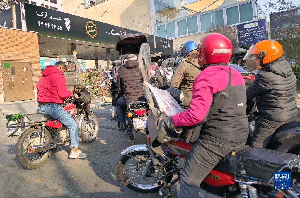 12月18日，摩托車在伊朗首都德黑蘭的一家加油站外等待加油。新華社記者 沙達(dá)提 攝