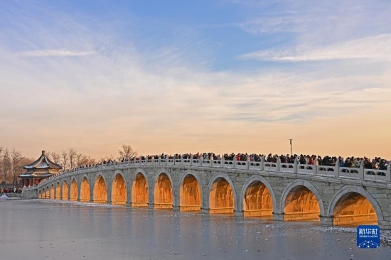 這是12月22日拍攝的頤和園十七孔橋“金光穿洞”景象。