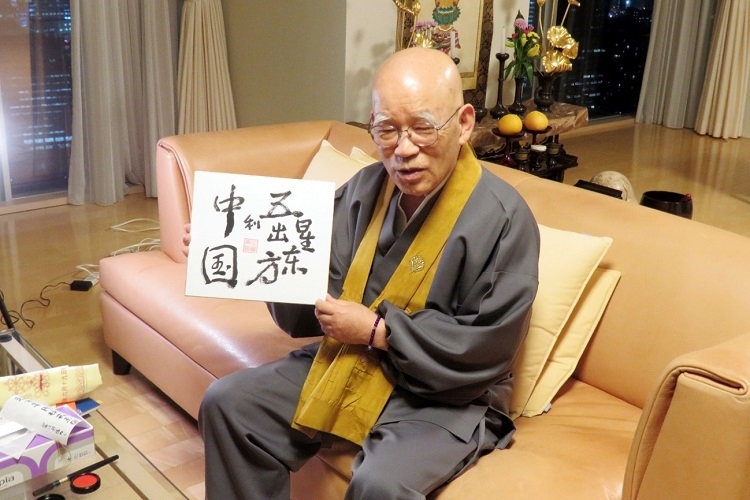 小島康譽展示自己書寫的“五星出東方利中國”。視頻截圖