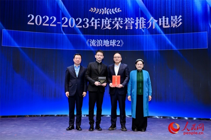 著名電影藝術(shù)家、事業(yè)家王曉棠（右一）和中國文聯(lián)書記處書記張宏（左一）為《流浪地球2》出品人、總監(jiān)制、總制片人傅若清（右二）與導(dǎo)演郭帆（左二）頒發(fā)“2022-2023年度榮譽推介電影”