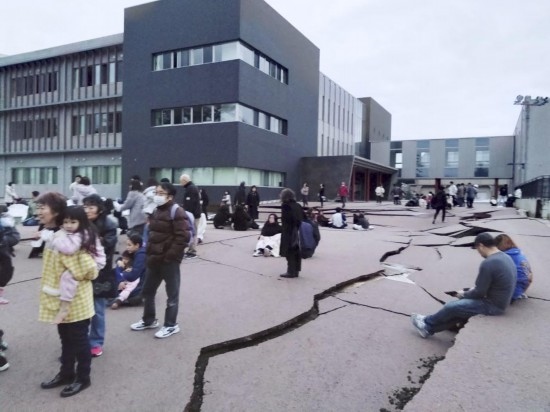  1月1日，在日本石川縣輪島市，人們站在被地震破壞的地面上。新華社/共同社