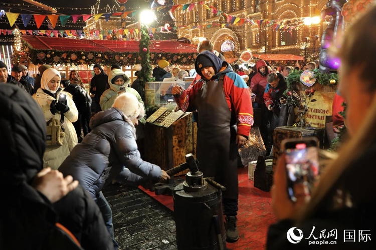 游客在新年集市上體驗(yàn)制作紀(jì)念幣。人民網(wǎng)記者 隋鑫攝