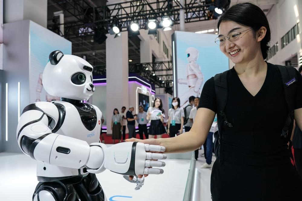 2023年8月16日，一名女士在北京舉辦的2023世界機器人大會現(xiàn)場與智能機器人握手。新華社記者彭子洋攝