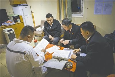 圖②：法官向船長(zhǎng)講解相關(guān)法律規(guī)定，查看船舶資料，并與船方辦理扣押船舶的手續(xù)。