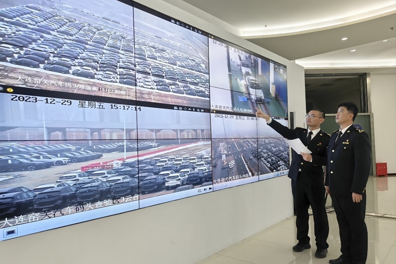 海關(guān)關(guān)員視頻巡查出口汽車場地。李進攝