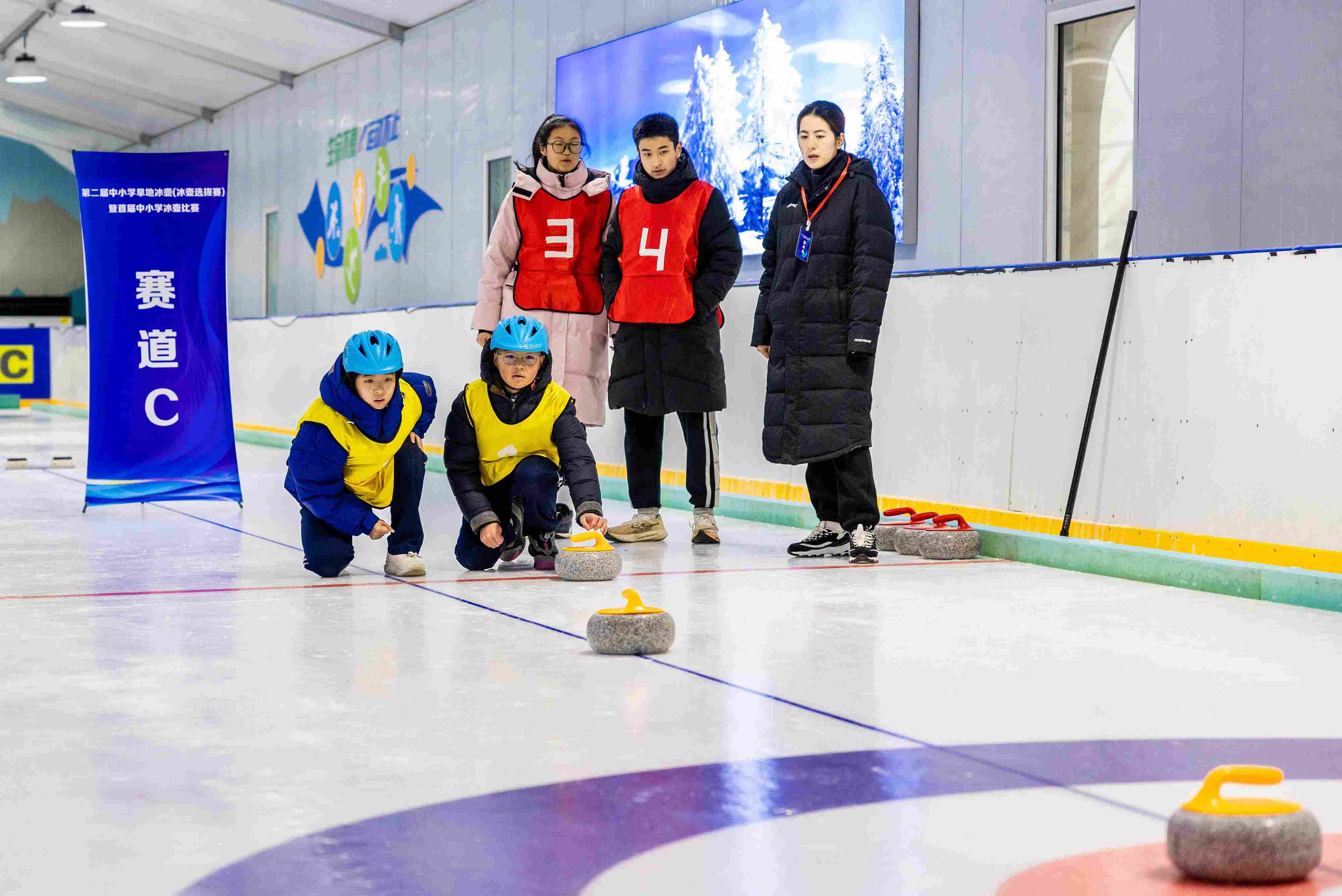 2023年12月10日，參賽選手在呼和浩特首屆中小學(xué)冰壺比賽中投擲冰壺。