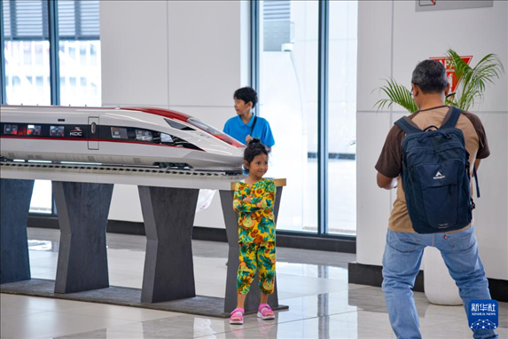 1月24日，在印度尼西亞雅加達(dá)哈利姆站候車大廳，一名小朋友和雅萬高鐵高速動(dòng)車組模型合影。新華社記者 徐欽 攝