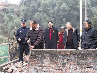  圖③：庭審結束后，在法官的見證下，陳某在院壩邊重新開鑿一條通道。