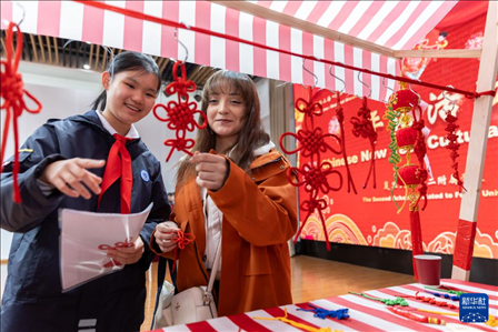 1月28日，復(fù)旦大學(xué)第二附屬學(xué)校學(xué)生（左）為美國馬斯卡廷中學(xué)學(xué)生（右）介紹中國結(jié)。 新華社記者 王翔 攝