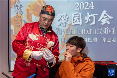 1月28日，在上海豫園舉行的民俗活動上，美國馬斯卡廷中學(xué)學(xué)生在非遺傳承人的指導(dǎo)下吹糖偶。 新華社記者 王翔 攝