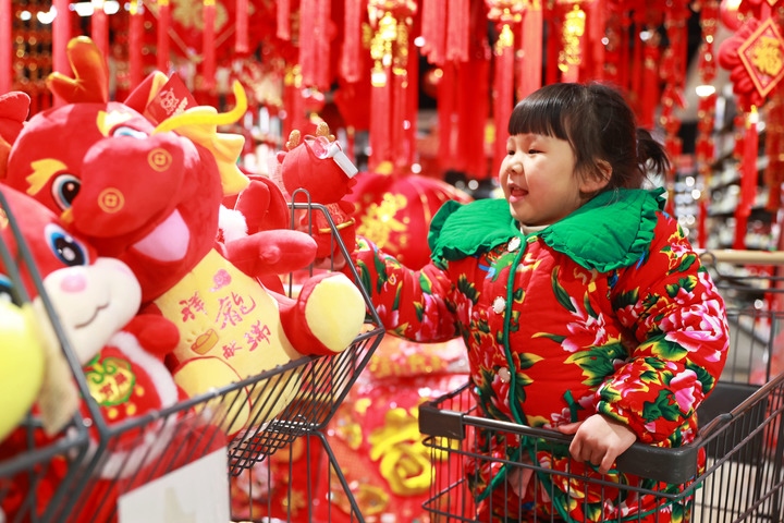 1月23日，在貴州省黔東南苗族侗族自治州岑鞏縣一家超市，小朋友在家人的帶領下選購龍年毛絨玩具。新華社發(fā)（唐鵬攝）