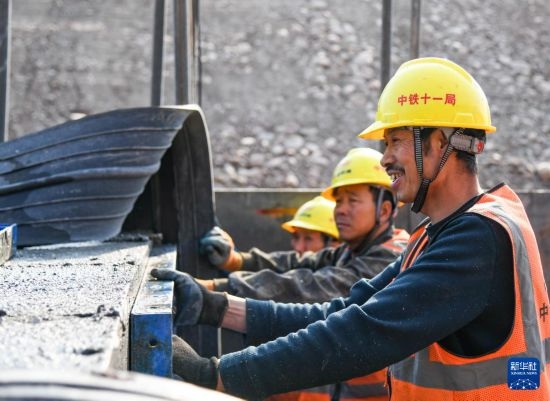 2月13日，在四川省通江縣青峪口水庫建設現(xiàn)場，中鐵十一局的工人正在進行混凝土縱向圍堰施工。