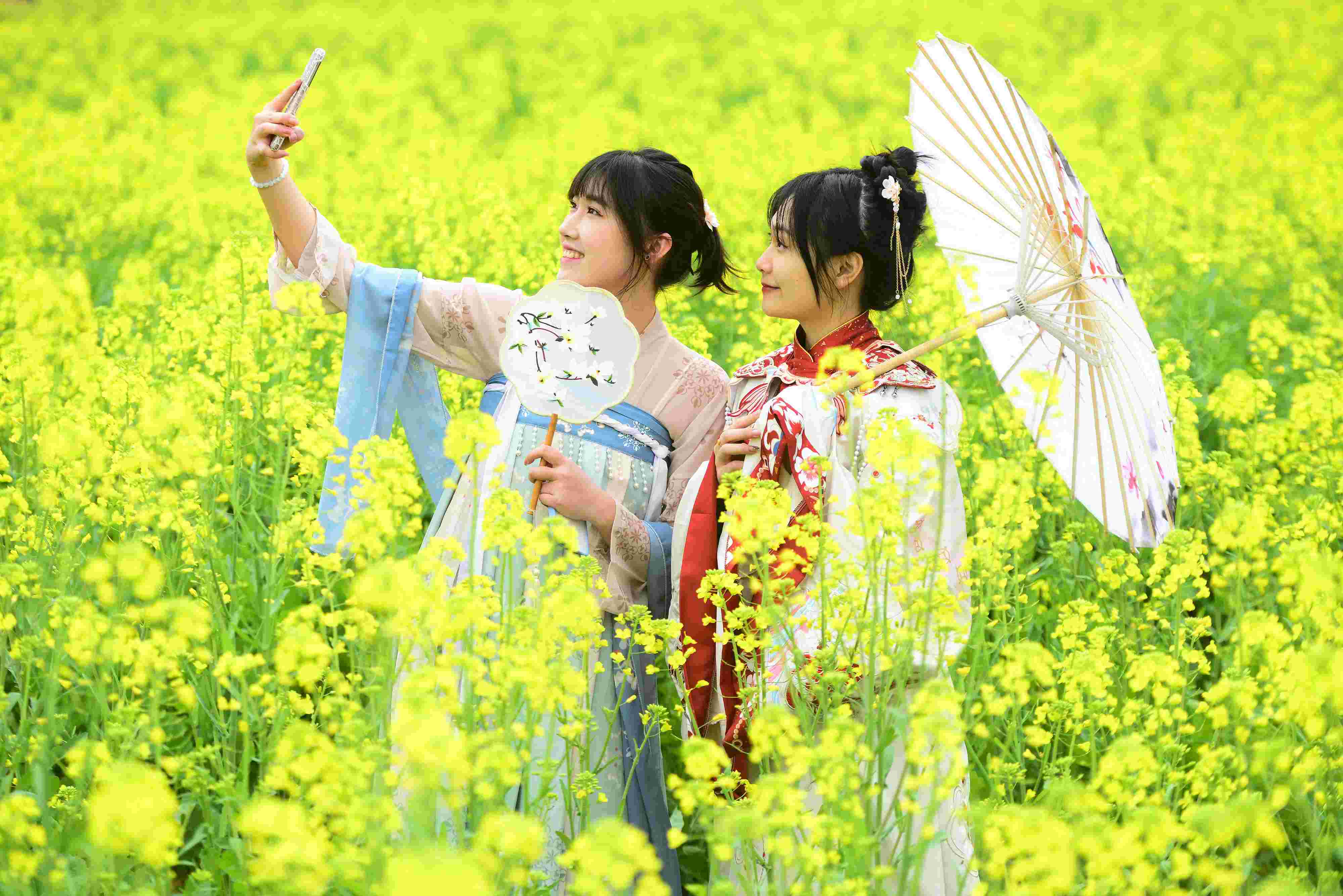 △ 2024年2月16日，廣西賀州，在富川瑤族自治縣麥嶺鎮(zhèn)三民村，游客在油菜花田間賞花拍照。