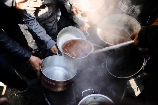  2月27日，在加沙地帶北部的杰巴利耶難民營(yíng)，人們領(lǐng)取食物。新華社發(fā)（穆罕默德·阿里攝）