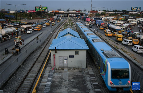 3月4日，在尼日利亞拉各斯，一列輕軌藍(lán)線列車行駛至公路交通擁堵路段附近。新華社記者 韓旭 攝