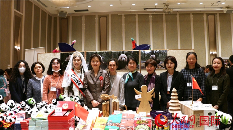中國駐日本大使吳江浩夫人丁玥（左五）與使館人員在展位前合影留念。人民網(wǎng) 許可攝