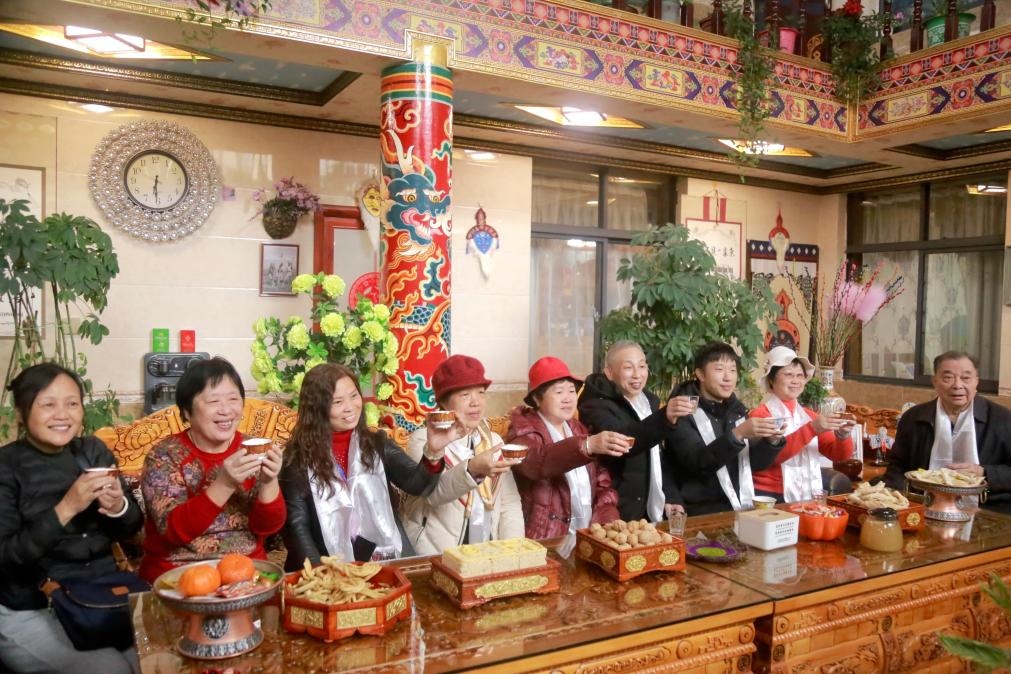 游客們?nèi)胱∶袼藓?，舉杯共飲酥油茶。新華社記者 邱星翔 攝