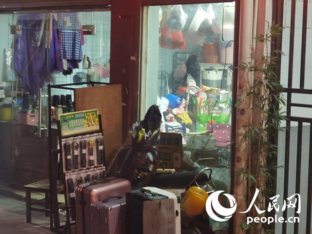 南寧“城中村”一裁縫鋪老板將電線從店內(nèi)拉出為電動(dòng)自行車充電。人民網(wǎng) 覃心攝
