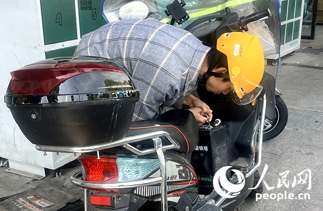 杭州一名外賣騎手正在更換共享電池。人民網(wǎng)記者 張麗瑋攝