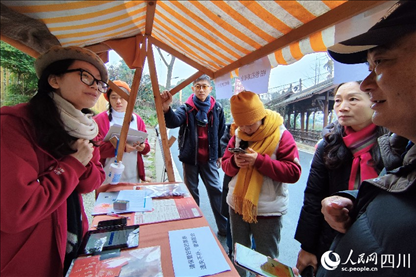 1月6日，“2024成都蒲江柑甜采摘節(jié)”上，記者見到了小萌（左一）和許多年輕人忙著做訪客接待、現(xiàn)場(chǎng)布置、票務(wù)核對(duì)、采摘服務(wù)等工作。人民網(wǎng)記者朱虹攝