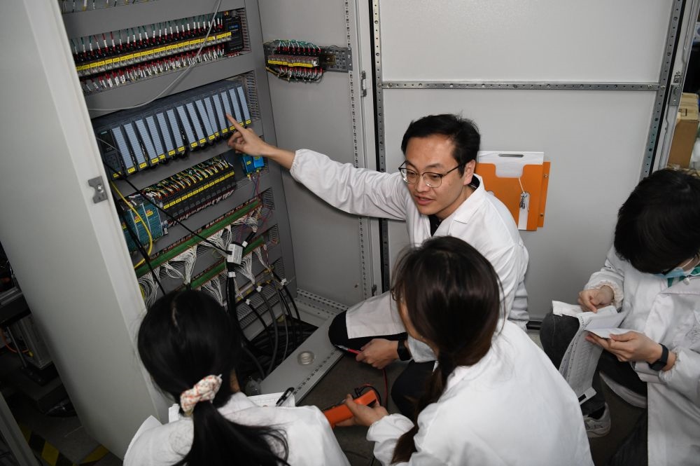 2024年4月6日，在位于安徽合肥的中國科學(xué)技術(shù)大學(xué)，安徽省先進(jìn)功能高分子薄膜工程實(shí)驗(yàn)室團(tuán)隊(duì)成員在檢修自主研制的高分子薄膜原位雙向拉伸實(shí)驗(yàn)設(shè)備的電氣控制系統(tǒng)。