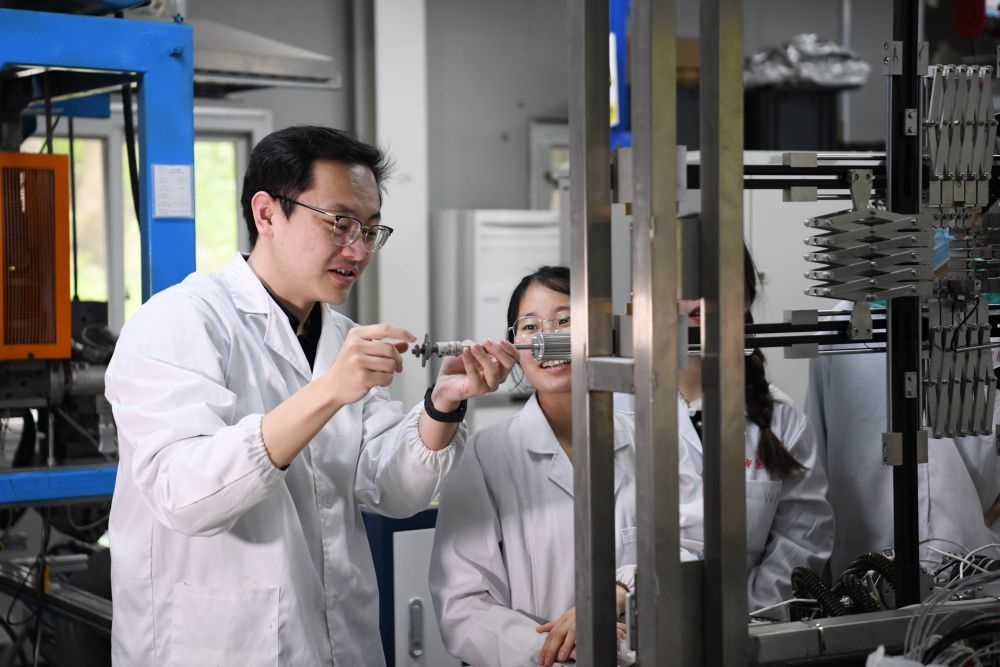 2024年4月6日，在位于安徽合肥的中國科學(xué)技術(shù)大學(xué)，安徽省先進(jìn)功能高分子薄膜工程實(shí)驗(yàn)室團(tuán)隊(duì)成員朱健和（左）在和同事討論實(shí)驗(yàn)設(shè)備的設(shè)計(jì)方案。