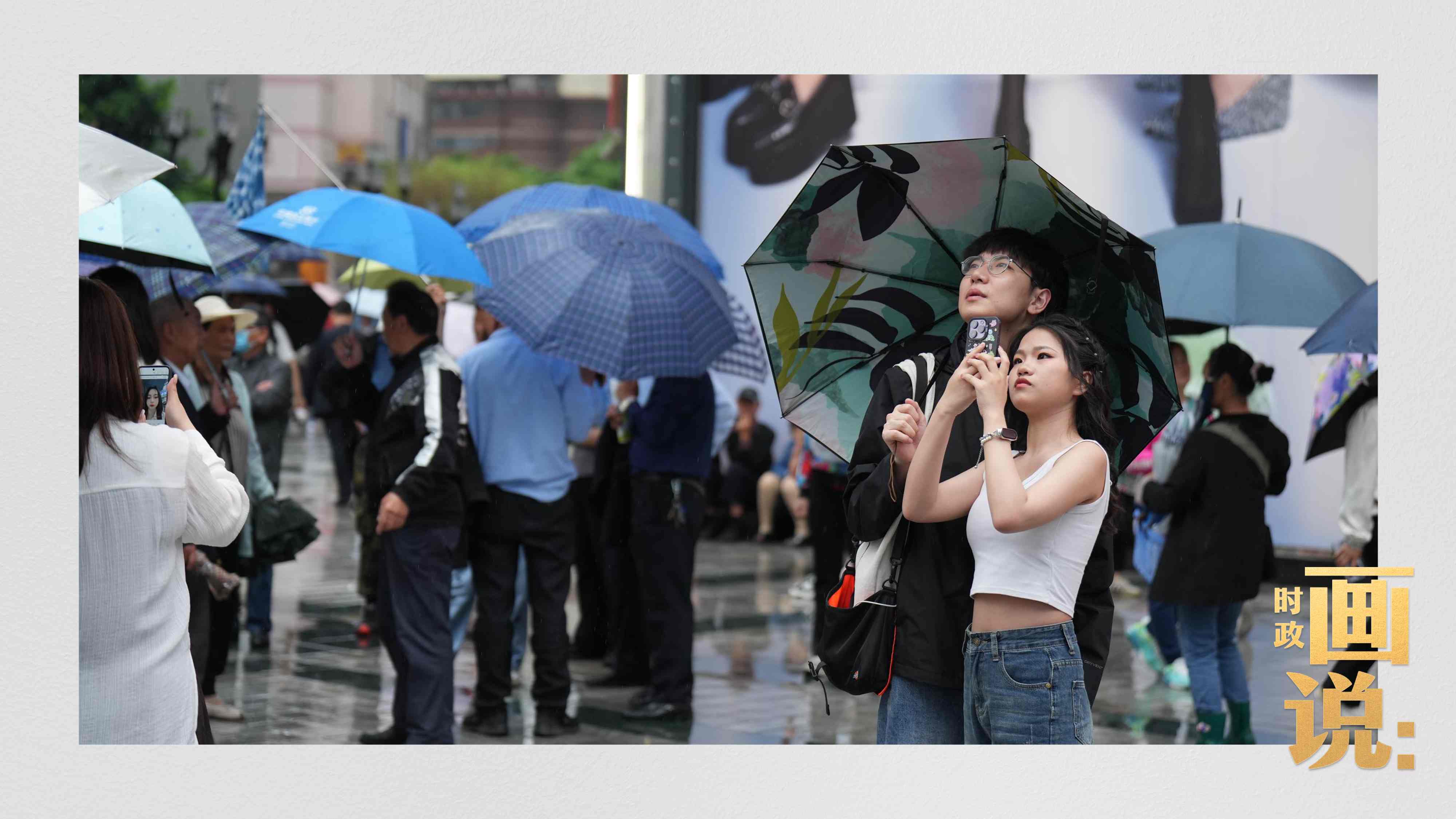 △細(xì)雨中的解放碑步行街，騎在父親肩膀的小女孩好奇張望。