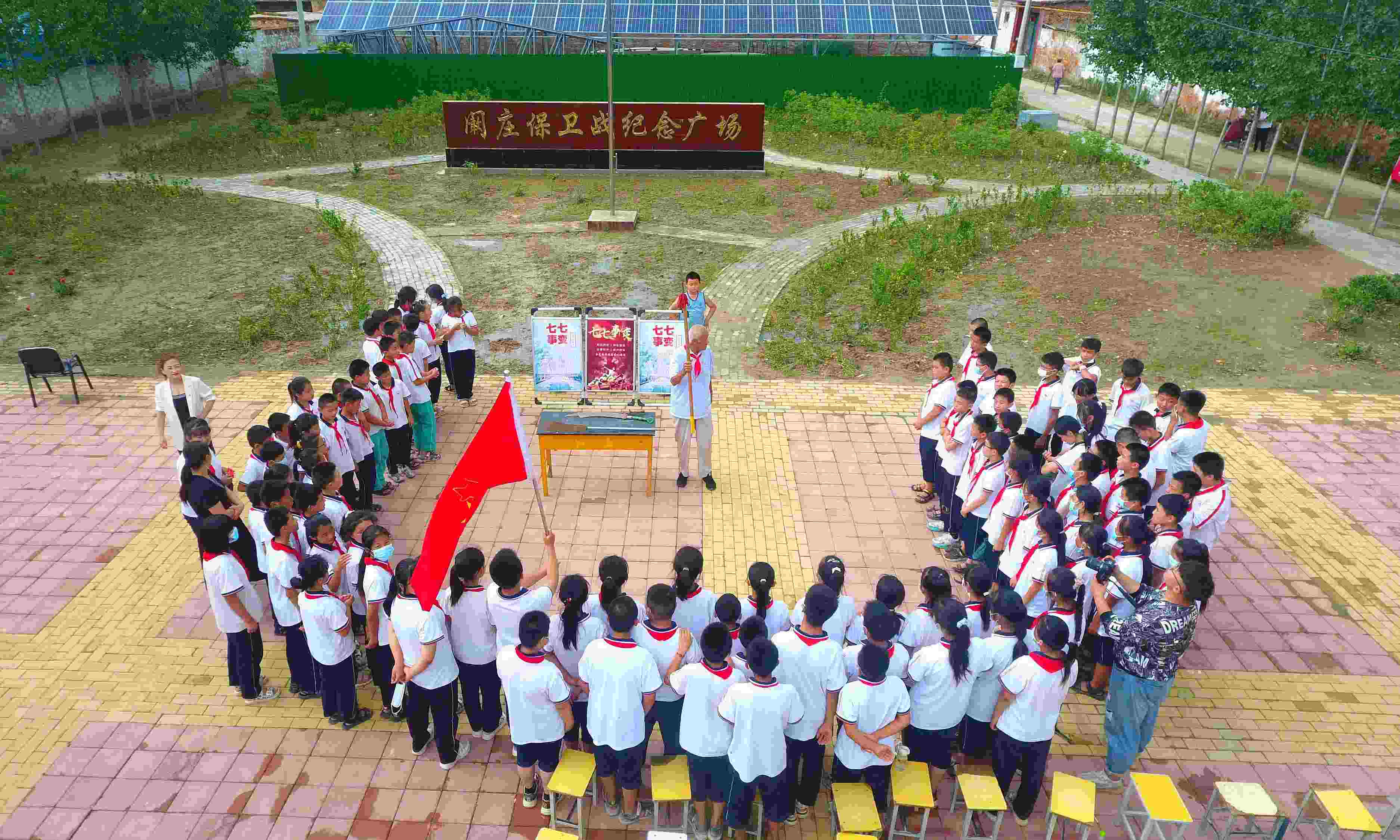 2022年7月6日，山東省聊城市，在茌平區(qū)菜屯鎮(zhèn)闞莊村的闞莊保衛(wèi)戰(zhàn)紀(jì)念廣場(chǎng)，闞莊保衛(wèi)戰(zhàn)親歷者王光木老人為小學(xué)生們講述抗戰(zhàn)故事，展示大刀、長(zhǎng)矛。