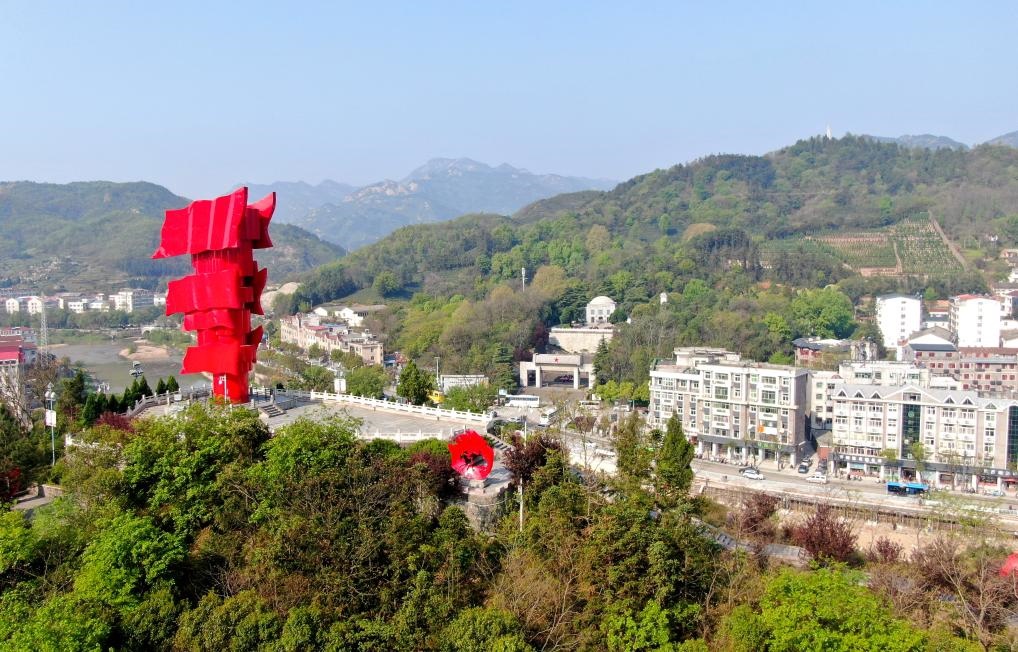 這是2021年4月9日拍攝的鄂豫皖蘇區(qū)首府革命博物館附近的英雄山上的“紅旗飄飄”主題雕塑（無(wú)人機(jī)照片）。新華社發(fā)