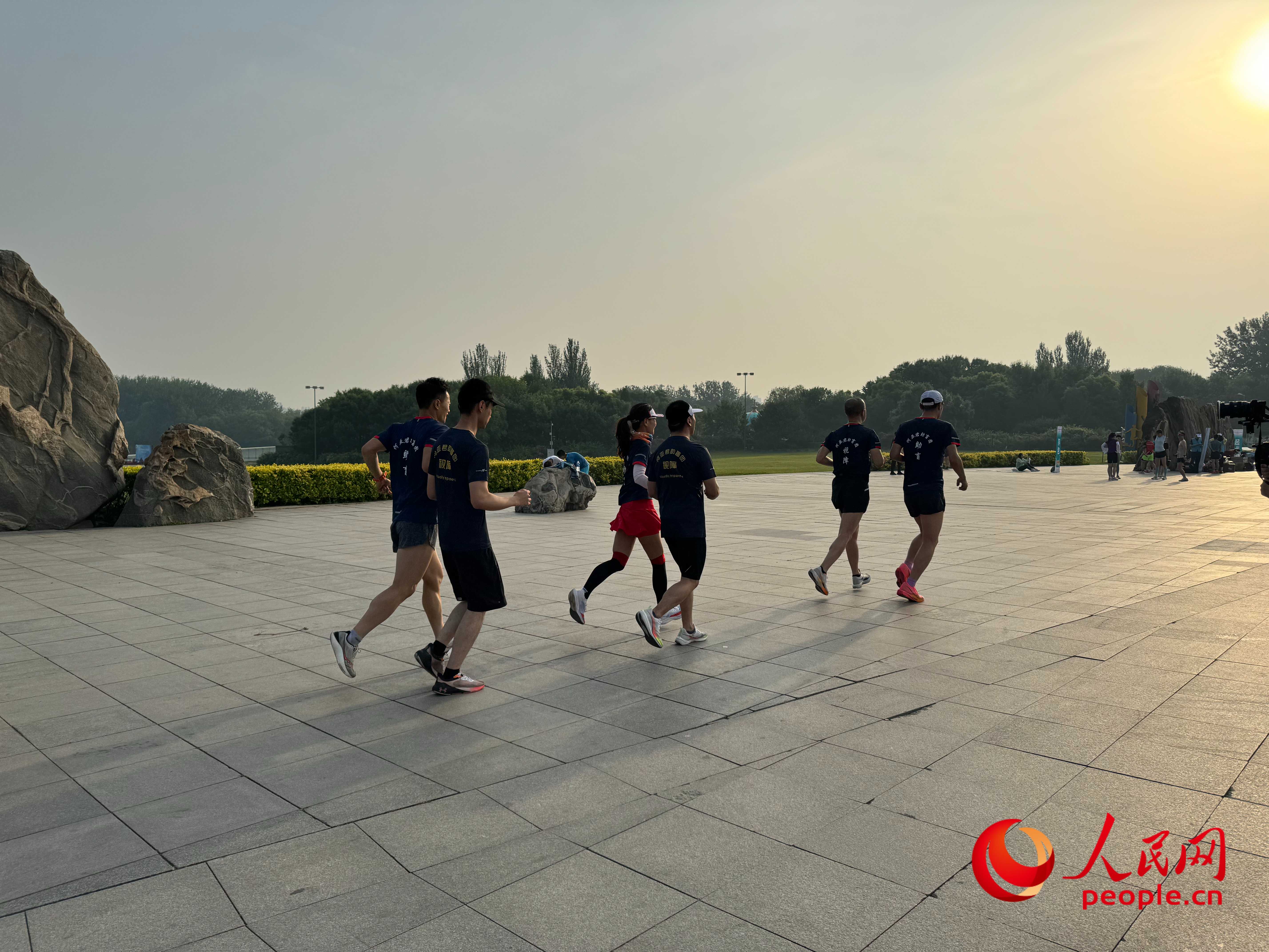 在北京奧林匹克森林公園，盲人跑團迎著朝陽在奔跑。人民網(wǎng) 周靜圓攝