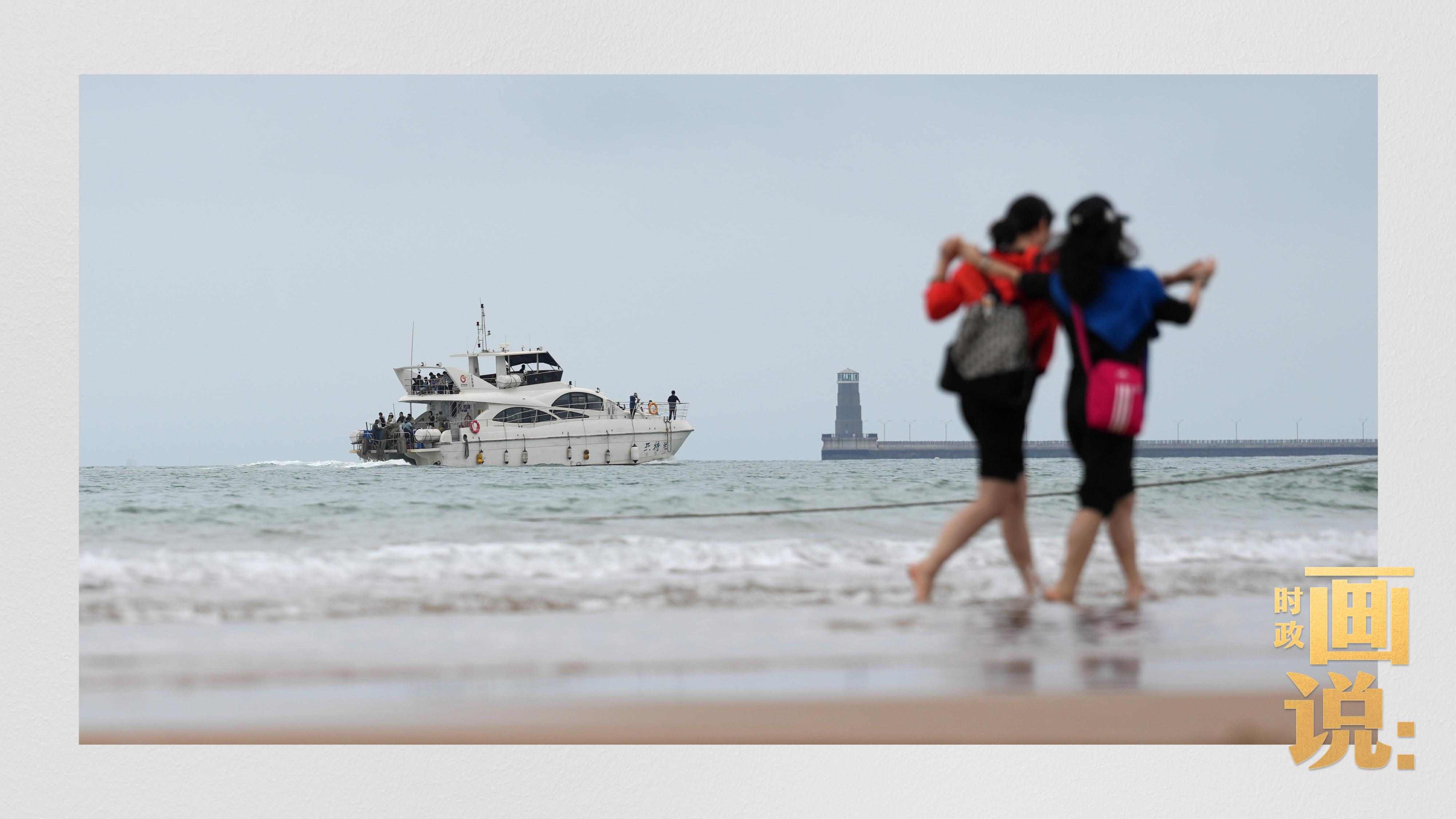 △日照陽光海岸綠道上的萬平口景區(qū)，一對游客在海浪中翩然起舞。