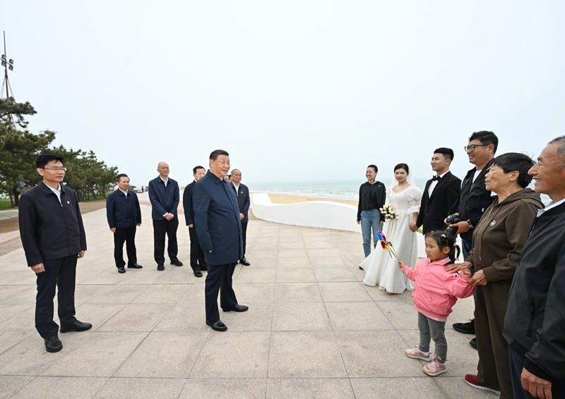 5月22日，在山東日照考察調(diào)研的習(xí)近平總書記來到陽光海岸綠道，同市民游客親切交流。