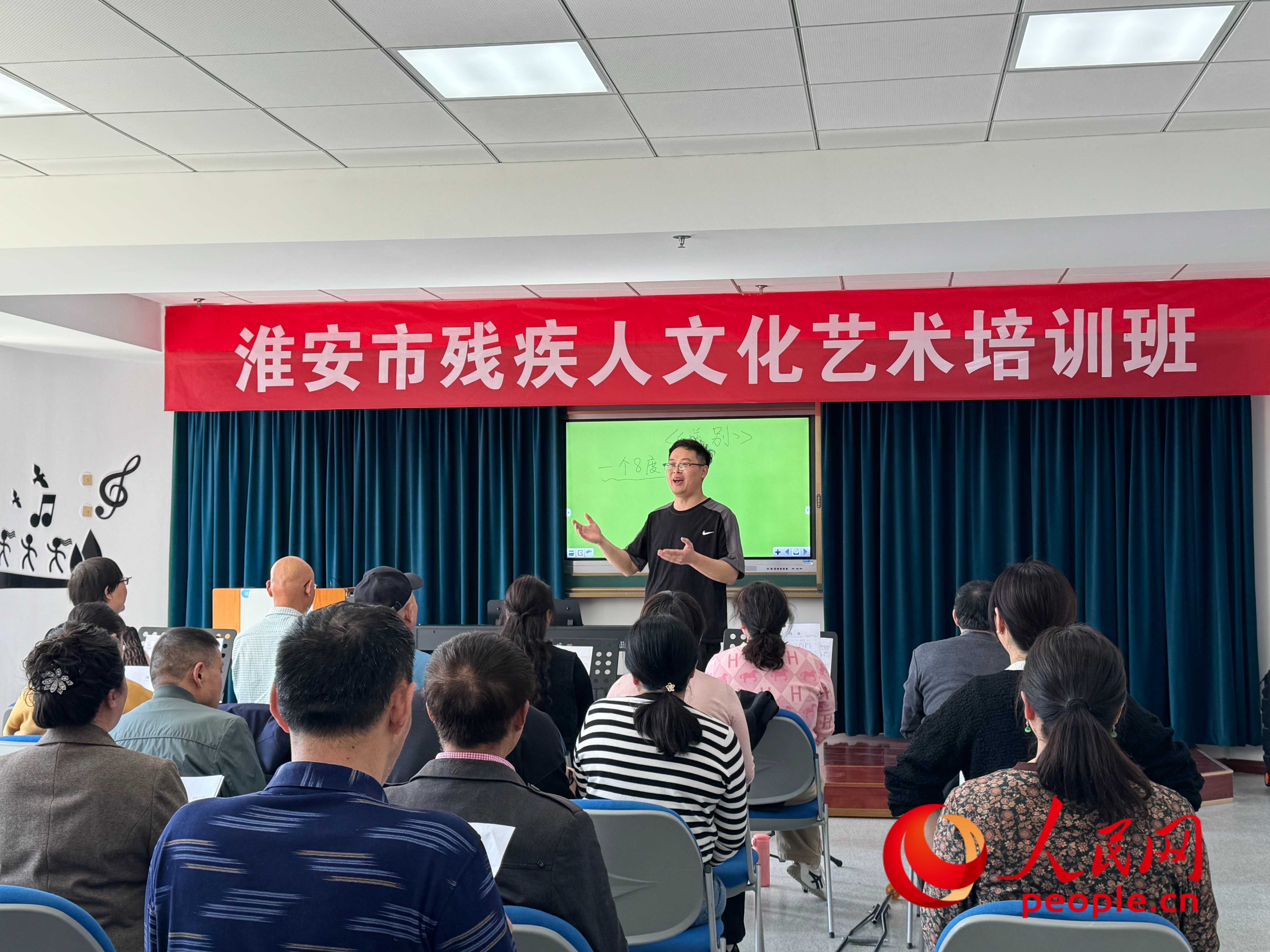 在淮安市殘疾人文化藝術培訓班上，聲樂老師在教殘疾人唱《送別》這首歌曲。人民網 周靜圓攝