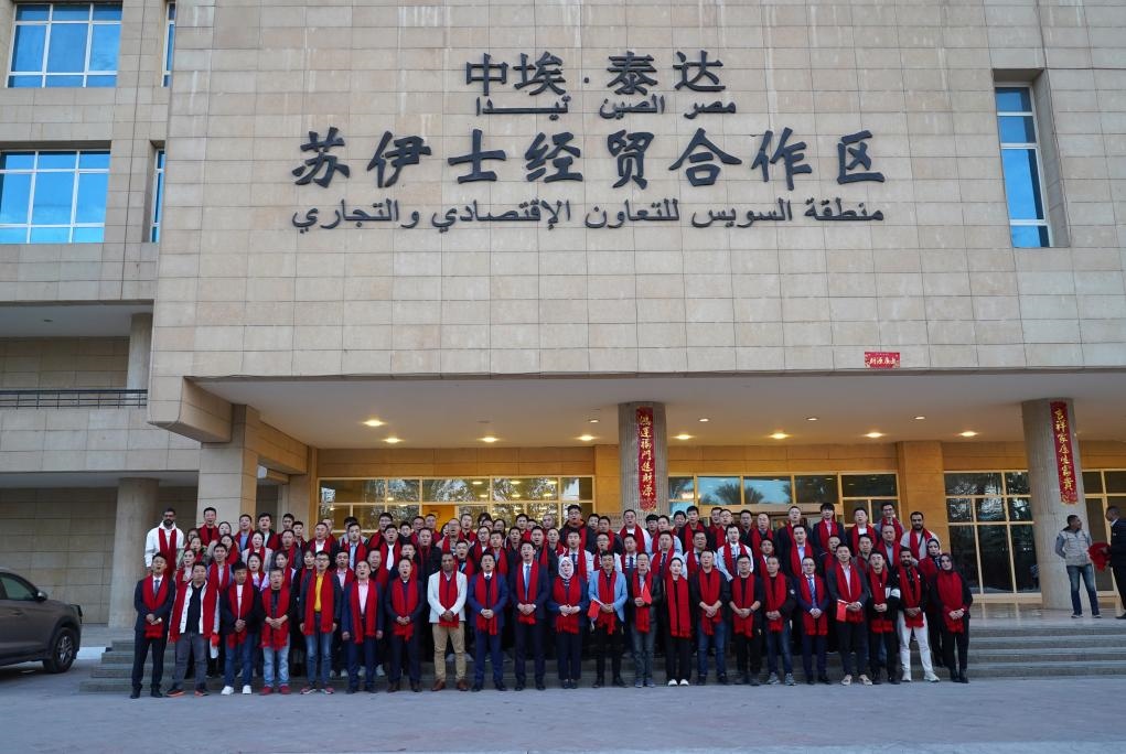 2024年2月11日，在位于埃及蘇伊士省的中?！ぬ┻_蘇伊士經(jīng)貿(mào)合作區(qū)，中埃員工在合作區(qū)辦公大樓前合影拜年。新華社發(fā)（泰達合作區(qū)供圖）