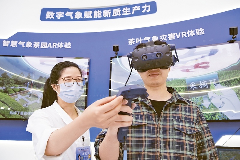 2024年5月23日，第七屆數(shù)字中國(guó)建設(shè)峰會(huì)現(xiàn)場(chǎng)體驗(yàn)區(qū)在福州海峽國(guó)際會(huì)展中心向?qū)I(yè)觀眾開(kāi)放。本次現(xiàn)場(chǎng)體驗(yàn)區(qū)圍繞本屆峰會(huì)主題“釋放數(shù)據(jù)要素價(jià)值，發(fā)展新質(zhì)生產(chǎn)力”，設(shè)置“數(shù)字惠民”、“數(shù)字能力”、“數(shù)字基礎(chǔ)”、“數(shù)字生態(tài)”、“數(shù)字賦能”五大板塊。圖為一名觀眾（右）在數(shù)字氣象賦能新質(zhì)生產(chǎn)力展臺(tái)上進(jìn)行體驗(yàn)。 新華社記者 魏培全/攝