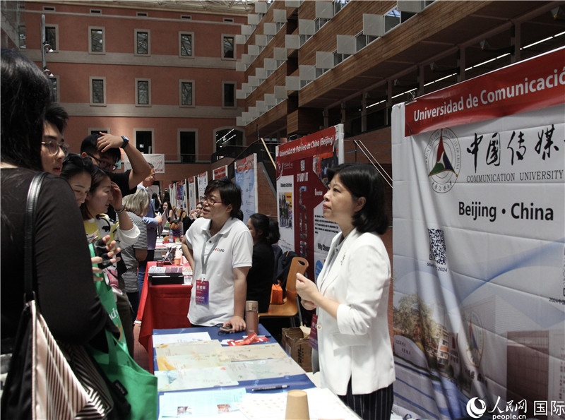 旅西華人華僑在展臺(tái)前咨詢。人民網(wǎng)記者 許海林?jǐn)z