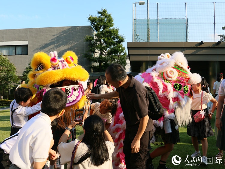 孩子們好奇地圍觀舞獅。人民網(wǎng) 許可攝