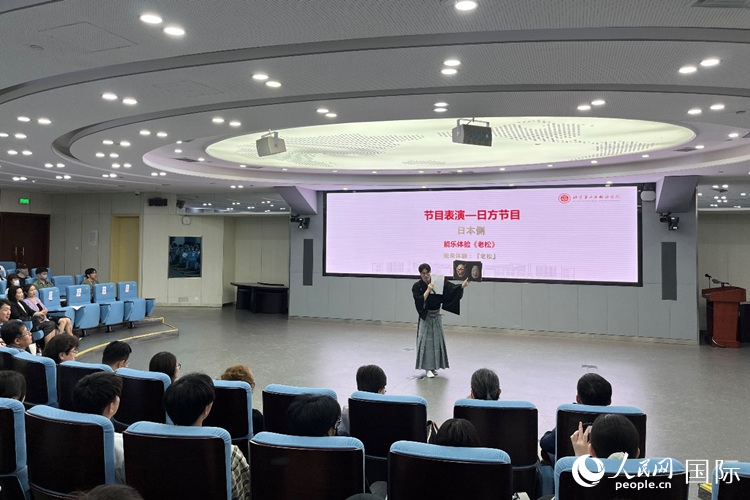 日本大學(xué)生介紹能樂(lè)知識(shí)。人民網(wǎng)記者 陳思攝