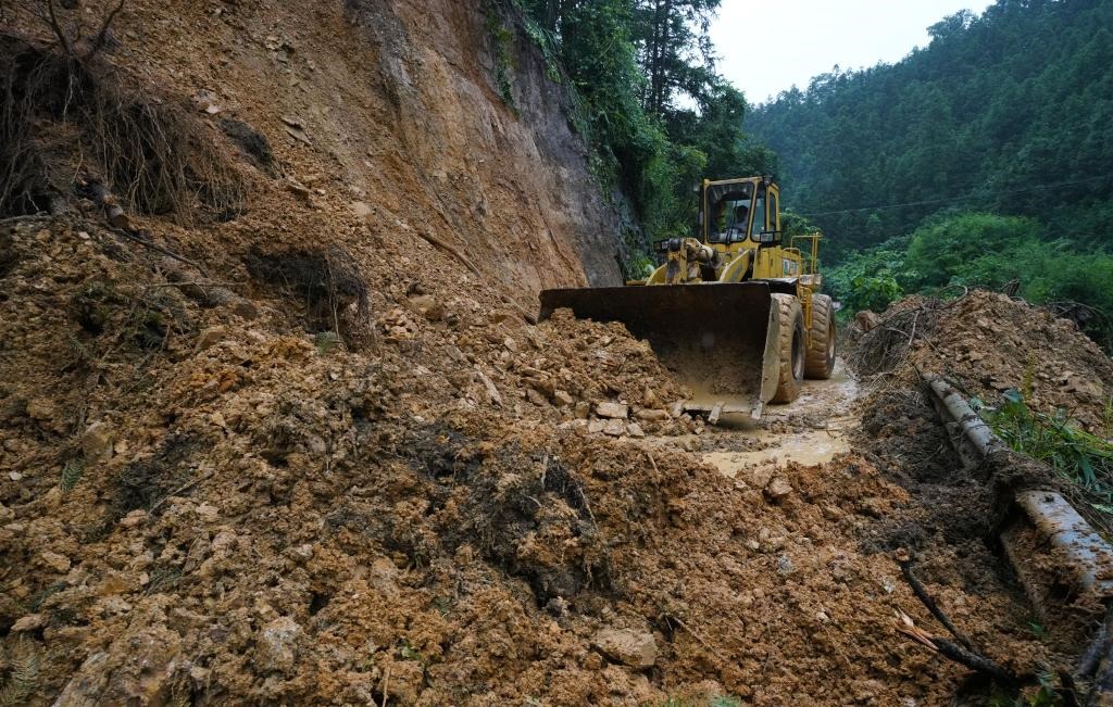 6月18日，在廣西融水苗族自治縣融水鎮(zhèn)新安村，一臺推土機在清理塌方路段。新華社發(fā)（龍林智攝）
