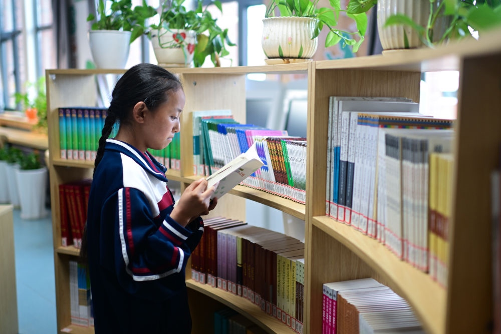 6月18日，果洛西寧民族中學(xué)學(xué)生尼東拉毛在圖書室看書。