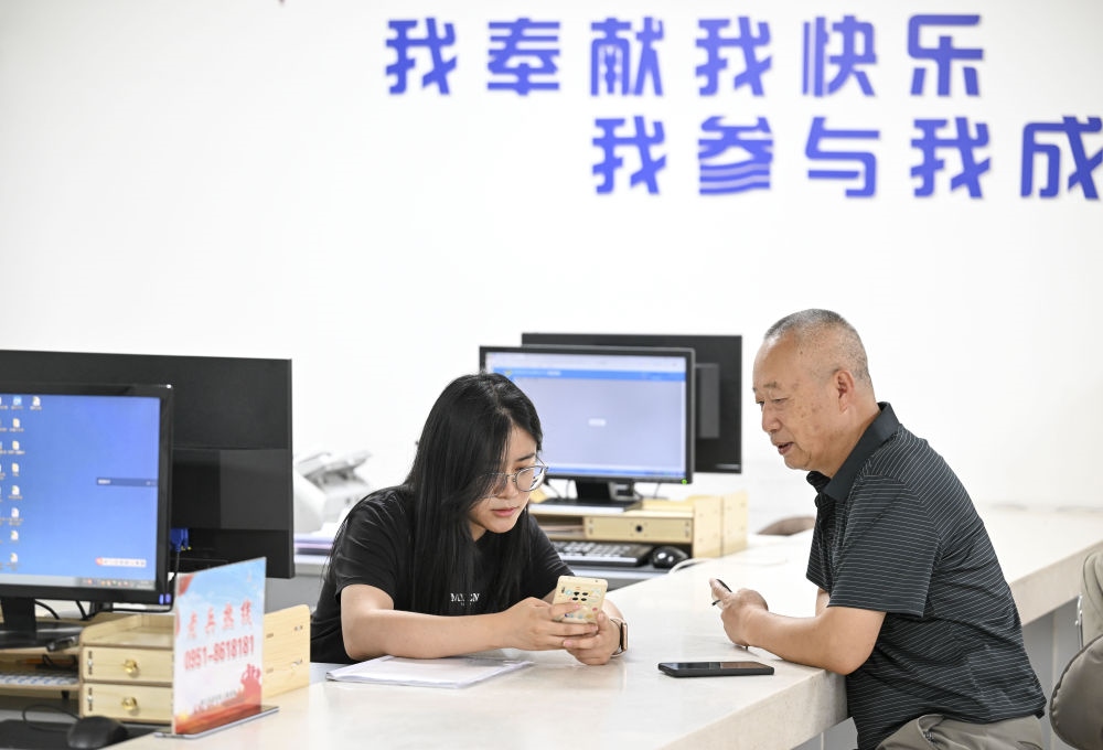 6月20日，在長城花園社區(qū)黨群服務中心，工作人員幫助居民辦理業(yè)務。