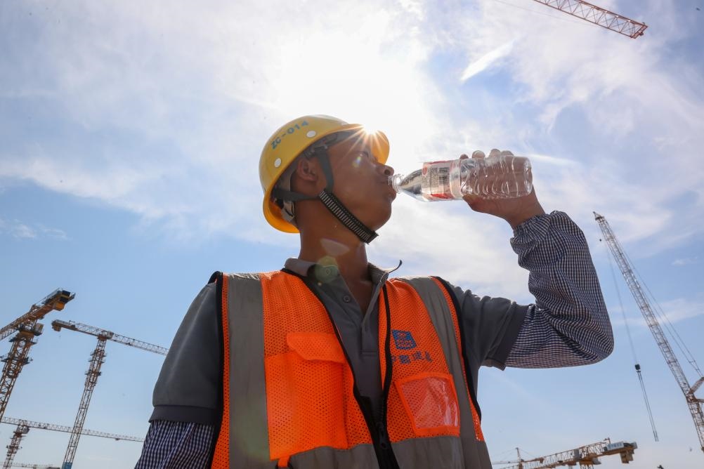 6月18日，在江蘇省無錫市奧體三期項目施工現(xiàn)場，中建二局工人在喝水解暑。新華社發(fā)（朱吉鵬 攝）