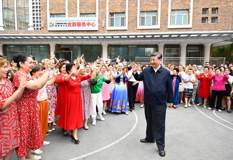 2022年7月13日，習(xí)近平總書記在新疆烏魯木齊市天山區(qū)固原巷社區(qū)考察時(shí)，向各族群眾揮手致意。