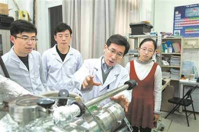 2017年10月，清華大學(xué)低維量子物理國(guó)家重點(diǎn)實(shí)驗(yàn)室，薛其坤（左三）與學(xué)生討論實(shí)驗(yàn)工作。 苑潔攝